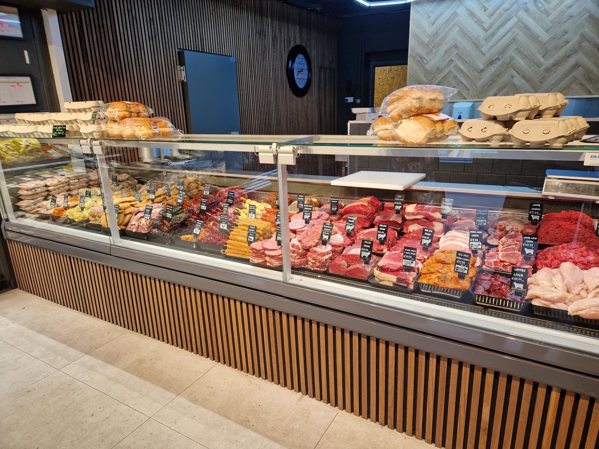 The Faulkner Butchery service counter and deli case beneath the herringbone feature wall