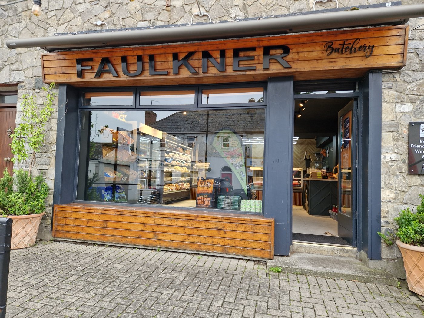 The Faulkner Butchery shopfront in Slane, Co. Meath — carved timber sign above the window display and open door